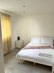 a bedroom with a white bed and a yellow curtain at Sleep In oxford in Oxford