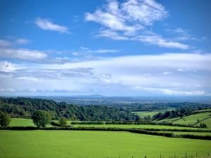 a green field with trees in the distance at 18th Century Farmhouse, England Wales Border, Breathtaking Views in Oswestry