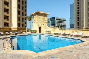 a large swimming pool with chairs and a building at KeyHost - Full Sea View Majestic 2BR Apartment - Rimal JBR - K2530 in Dubai