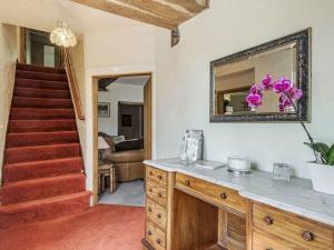 a living room with a staircase and a mirror at 18th Century Farmhouse, England Wales Border, Breathtaking Views in Oswestry
