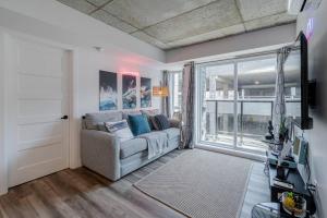 a living room with a couch and a large window at NOUVEAU - CONDO 2CH - VIEUX-QUÉBEC in Quebec City