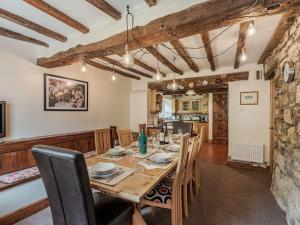 a dining room with a wooden table and chairs at Cynynion Uchaf - Countryside Farmhouse with Views in Oswestry