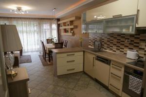 a kitchen with a table and a dining room at Ede Apartman in Gyula