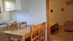 a kitchen and dining room with a wooden table and chairs at Danaides Bungalows in Tolo