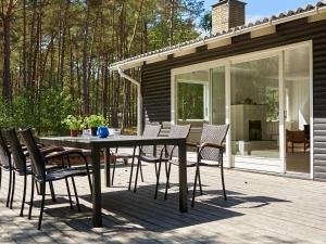 patio ze stołem i krzesłami na tarasie w obiekcie 7 person holiday home in Nex w Nexø