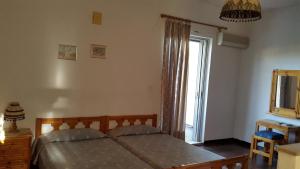 a bedroom with a bed and a large window at Danaides Bungalows in Tolo +4 photos
