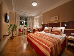 a bedroom with a large bed and a living room at EA Hotel Julis in Prague