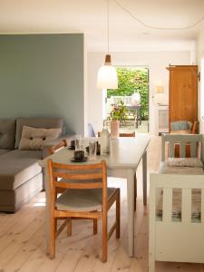 a living room with a table and chairs at Kamilla's cottage, 1 km. from the beach in Stege