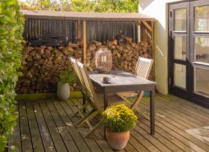 een tafel en twee stoelen op een houten terras bij Kamilla's cottage, 1 km. from the beach in Stege