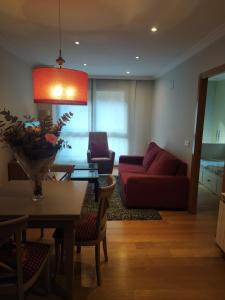 uma sala de estar com um sofá vermelho e uma mesa em Apartamento en el centro con garaje directo. em Bilbao