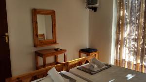 a room with a mirror and a table and a mirror at Danaides Bungalows in Tolo