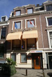 a hotel building with flags on the front of it at Hotel Domstad in Utrecht