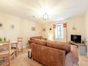 Sala de estar con 2 sofás y mesa en Llanfair Hill Cottage en Cwrt-newydd