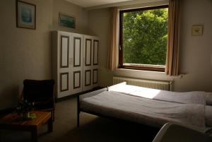 ein Schlafzimmer mit einem Bett, einem Fenster und einem Stuhl in der Unterkunft Hotel Domstad in Utrecht
