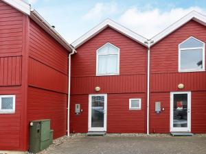 un bâtiment rouge avec deux fenêtres dans l'établissement 6 person holiday home in Hadsund, à Hadsund
