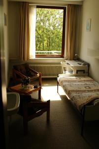 ユトレヒトにあるホテル ドムステッドのベッド1台、ソファ、窓が備わる客室です。