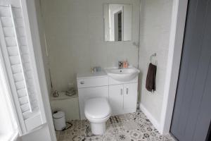 Baño blanco con aseo y lavamanos en Ugthorpe Lodge Hotel en Whitby