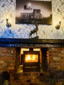 Una chimenea de ladrillo con fuego. en Ugthorpe Lodge Hotel en Whitby