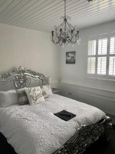 a bedroom with a large bed with a chandelier at Ugthorpe Lodge Hotel in Whitby