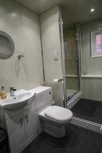 a bathroom with a shower and a toilet and a sink at Ugthorpe Lodge Hotel in Whitby