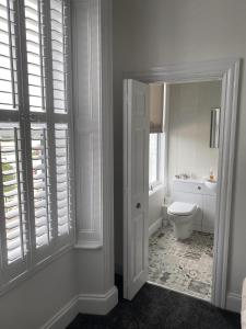 a white bathroom with a toilet and a window at Ugthorpe Lodge Hotel in Whitby