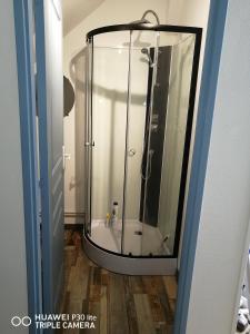 eine Dusche mit Glastür im Bad in der Unterkunft Studio grand lit 160 tout équipé wifi in Le Creusot