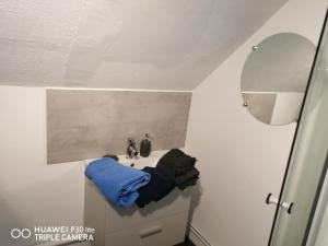 ein Badezimmer mit einem Waschbecken und einem blauen Handtuch darauf in der Unterkunft Studio grand lit 160 tout équipé wifi in Le Creusot