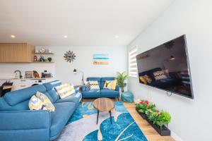uma sala de estar com sofás azuis e uma mesa em 37 Galaxy B em Lake Tekapo