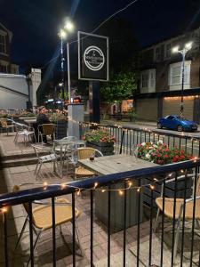 una mesa con sillas y flores en un patio por la noche en The New Brighton Hotel, en New Brighton