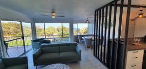 a living room with a couch and a table and chairs at Pandanus Coolum Beach in Coolum Beach