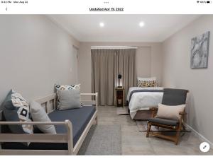 德爾斯特魯姆的住宿－Rueby’s Apartment 101，一间卧室配有一张床、一张沙发和一把椅子