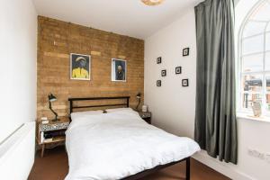 ein Schlafzimmer mit einem Bett und einer Ziegelwand in der Unterkunft The Brewhouse, Castle Brewery, Newark in Newark upon Trent