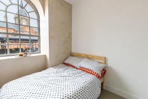 a small bedroom with a bed and a window at The Brewhouse, Castle Brewery, Newark in Newark-on-Trent