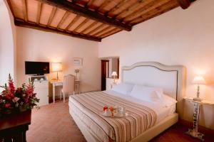 a hotel room with a bed and a tv at Borgo Sant'Ambrogio - Resort in Pienza