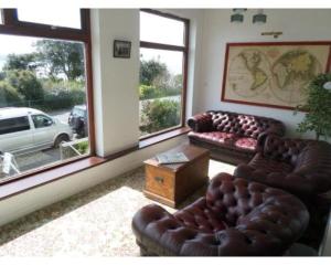 a living room with couches and a table and windows at Savoy B&B in Weston-super-Mare