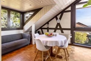 ein Esszimmer mit einem Tisch und einem Sofa in der Unterkunft Ferienwohnung Cherine in Gailingen