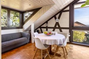 a dining room with a table and a couch at Ferienwohnung Cherine in Gailingen