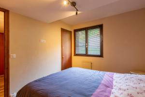 ein Schlafzimmer mit einem blauen Bett und einem Fenster in der Unterkunft Le Beauregard in Le Grand-Bornand