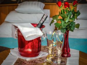 una mesa con una tetera roja y un jarrón con rosas en Apartament Kamienica, en Płock