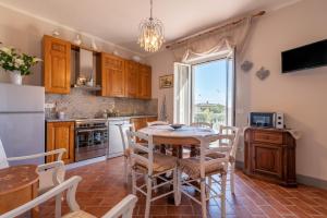 a kitchen with a table and chairs and a kitchen with a window at Casa del Nonno Bingheri - L'Olivo in Cortona