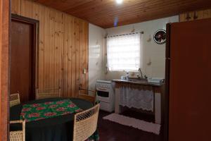 eine kleine Küche mit einem Tisch und einem Waschbecken in der Unterkunft Chalés Dona Zenta in Monte Verde
