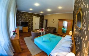 1 dormitorio con 1 cama azul y sala de estar en Apartament Kamienica, en Płock