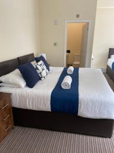 a bedroom with a large bed with towels on it at The New Brighton Hotel in New Brighton