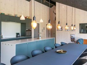 une cuisine avec une table bleue, des chaises et des lampes pendant dans l'établissement 12 person holiday home in Haderslev, à Haderslev