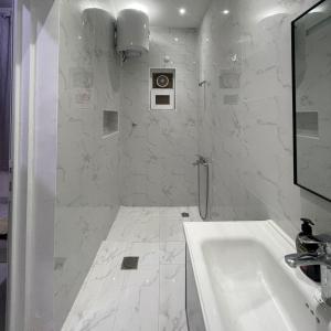 bagno bianco con lavandino e specchio di Dhakira Resort a Adh Dhakhīrah