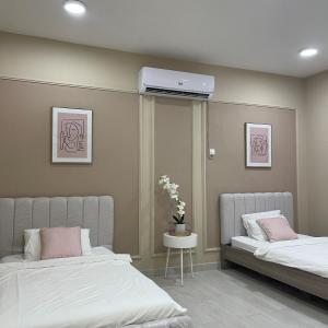 a bedroom with two beds and a air conditioner on the wall at Dhakira Resort in Adh Dhakhīrah