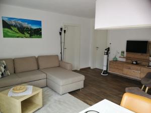 sala de estar con sofá y TV de pantalla plana en Birnbacher-appartement, en Sankt Veit im Pongau
