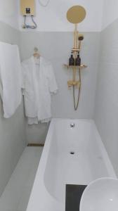 een witte badkamer met een wit shirt en een spiegel bij Angels Bed and Breakfast Sipalay City by RedDoorz in Sipalay