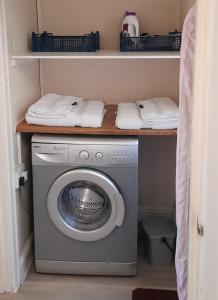 a laundry room with a washing machine on a shelf at Garden Cottage, Five Pines in Acton Turville