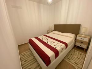 sypialnia z łóżkiem z czerwonym i białym kocem w obiekcie Casa do Calhau - AL w mieście Hombres